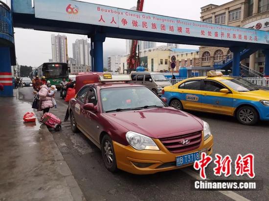 On February 13, people took a taxi at Liuzhou South Bus Station, and the driver got off to help carry luggage.